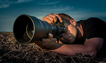 Fotograf liegt auf dem Boden von vorne in Großaufnahme - vhs Demohausen - www.itemkg.de
